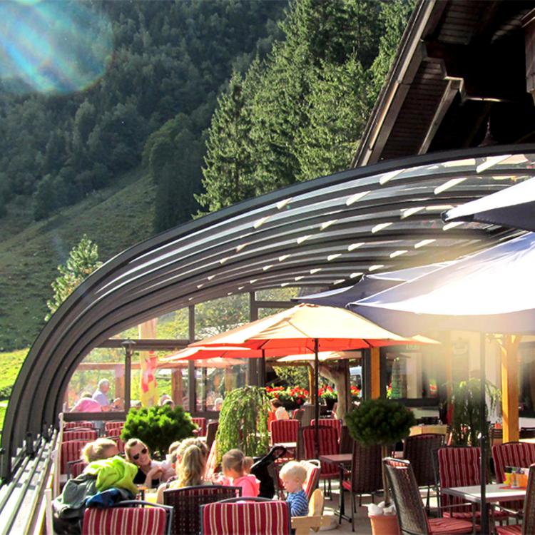 Abri véranda de restaurant rétractable et ici en position ouverte grâce au beau temps
										