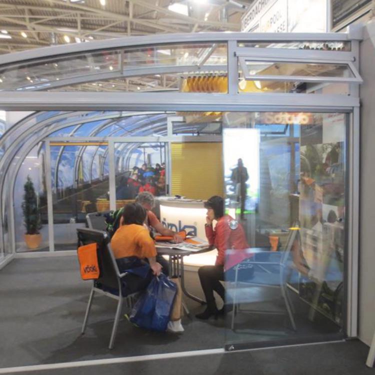 Abri de terrasse Saphir exposé sur le stand Vöroka à la foire
										- Façade mur de verre